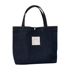 Minimalist dark blue denim tote bag featuring a cute cartoon bear patch and orange stitching