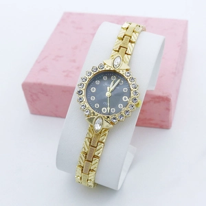 Vue détaillée d'une montre à quartz dorée sertie de diamants dans un coffret cadeau rose