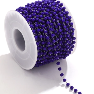 Macro view of purple faceted crystal beads on a stainless steel chain for DIY jewelry