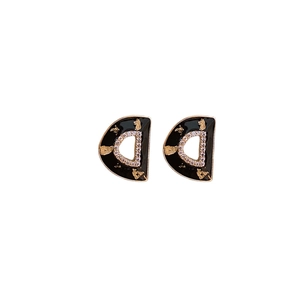 Elegant gold D-letter earrings with black enamel, gold leaf texture, and white zircon crystals