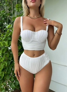 Close-up of white ribbed knit swimsuit fabric with shaping cups and high waist design