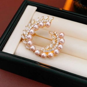Macro view of peach pink pearl and zircon accents on a vintage gold-plated brooch