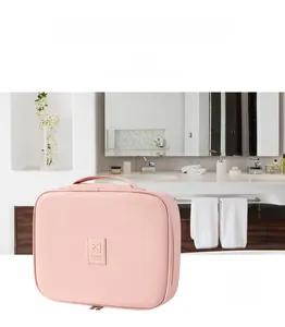 Pink PU leather travel wash bag with top handle and dual zipper in a bathroom setting