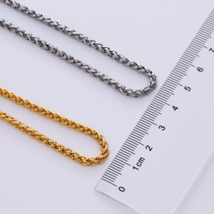 Detailed comparison of 3mm gold and silver stainless steel wheat chain with scale ruler