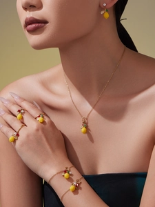 Vue détaillée d'une parure bijoux citron jaune avec collier, boucles d'oreilles et bagues