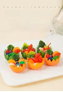 Detail view of miniature resin fruit bowl models with colorful strawberry and orange slices