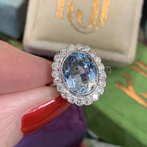 Elegant floral halo ring with oval sea blue zircon and sparkling white crystals