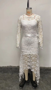Detail of white lace dress with floral hollow-out fabric and irregular high-low hemline