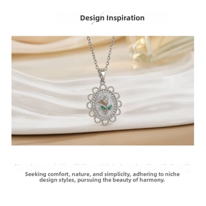 Close-up of vintage oval rose pendant with green leaf accents and sparkling stone border