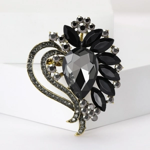 Detail of vintage gold brooch with grey pear-shaped and black marquise crystals