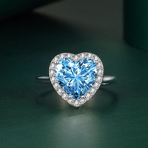 Vue macro d'une bague en saphir bleu en forme de cœur avec un halo de zircons blancs