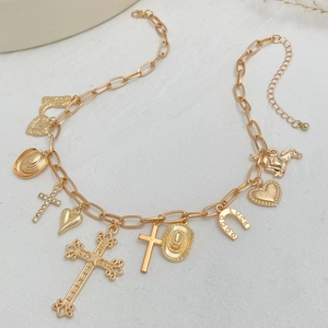 Close-up of golden vintage charms including cowboy hats, crosses, and lucky horseshoe