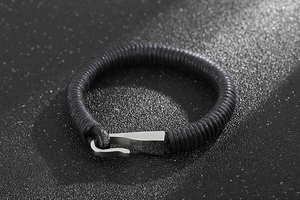 Detail of black braided leather cord and silver stainless steel hook clasp for men