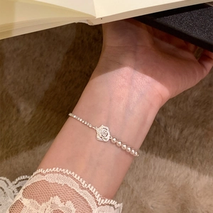 Elegant flower and pearl bracelet with zircon stones and asymmetrical chain design