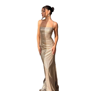 Detail of shimmering gold sequin fabric on a slim-fit evening dress with a cross-back design