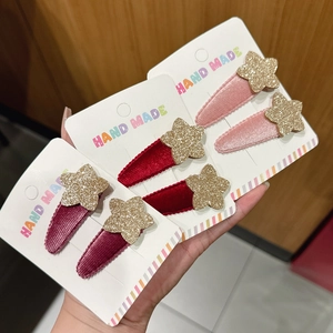 Dettaglio di fermagli per capelli a stella in velluto rosa e rosso su schede regalo