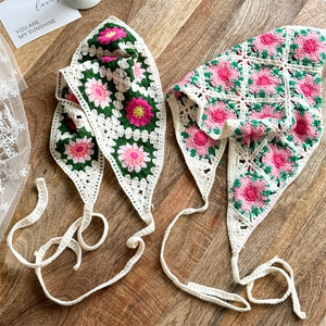 Close-up of handmade floral crochet headscarves on a natural wooden background