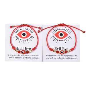 Close-up of two pink evil eye bracelets on a card with symbolic protective meaning