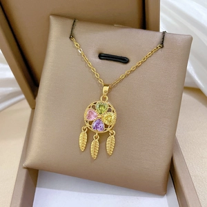 Detailed shot of gold dreamcatcher necklace with colorful heart stones in a gift box