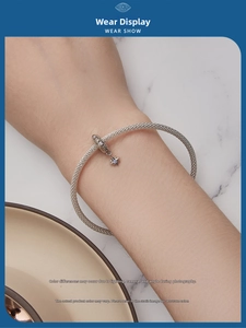 Detail of silver mesh weave bracelet with star charm pendant worn on wrist