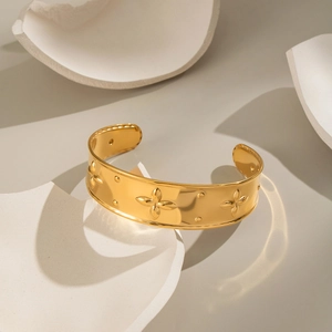 Modern 18K gold plated open bangle with embossed clover pattern and polished metal texture