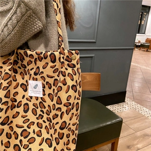 Detail of leopard print corduroy tote bag showing thick texture and metal rivet handle