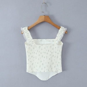 Detail van witte bloemen camisole met elastisch geplooid lijfje en kanten ruches bandjes