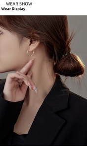 Close-up of minimalist S925 sterling silver water wave hoop earring worn on model