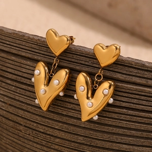 Detailed view of 18K gold plated heart earring with elegant pearl embellishments