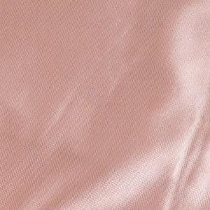 Detail of elegant champagne pink satin fabric with smooth texture and glossy finish