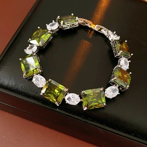 Macro view of olive green square zircon bracelet with silver finish on black texture