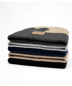 Dettaglio ravvicinato di berretti in maglia spessa in vari colori con patch in pelle