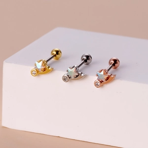 Detail of star and moon cartilage studs with opal stones in gold, silver, and rose gold