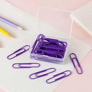 Close-up of purple coated paper clips in a transparent storage box on a desk
