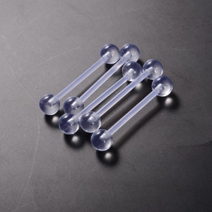 Set of four transparent acrylic tongue rings with straight bars on grey textured surface