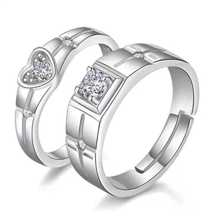 Close-up of heart and square cut couple rings with adjustable silver open bands