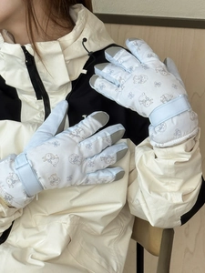 Detail of waterproof ski gloves featuring cute rabbit prints and adjustable wrist straps