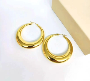 Detail of 18K gold plated thick crescent hoop earrings with polished stainless steel finish
