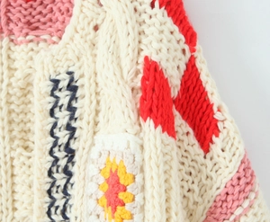 Détail macro du patchwork au crochet multicolore et texture en maille torsadée sur le pull