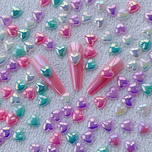 Pink coffin press-on nails featuring aurora 3D heart charms with vibrant iridescent finish