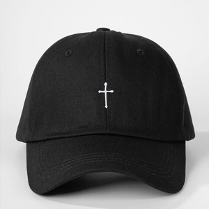 Detailed view of white cross embroidery on premium black cotton twill baseball cap