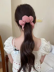 Detail of red and white checkered floral scrunchie on model ponytail hairstyle