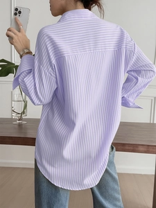 Back view of a loose-fit light purple striped shirt featuring curved hem and back yoke