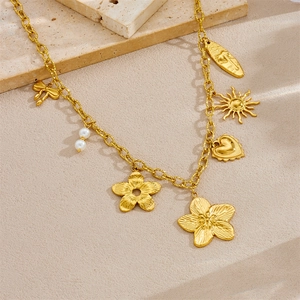 Gold plated stainless steel necklace with flower, heart, bow, and sun charms on stone
