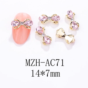 Nahaufnahme der 14x7mm Schleifen-Nagelkunst mit rosa Steinen und Gold-Finish