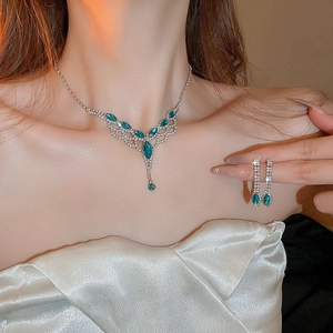 Vintage necklace and earring set with waterdrop teal gems and rhinestones on a model