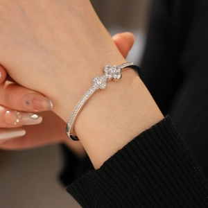Detailed macro view of silver clover bangle with shimmering zircon stones and beaded edges