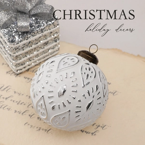 Detail of 8cm white and silver floral Christmas ball with vintage copper hook on paper
