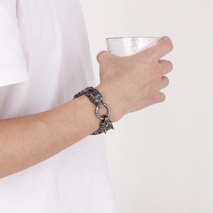 Close-up of double wolf head bracelet in polished titanium steel on model wrist