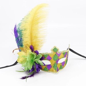 Detail of masquerade mask with vibrant feathers, sequins and purple green fabric flower